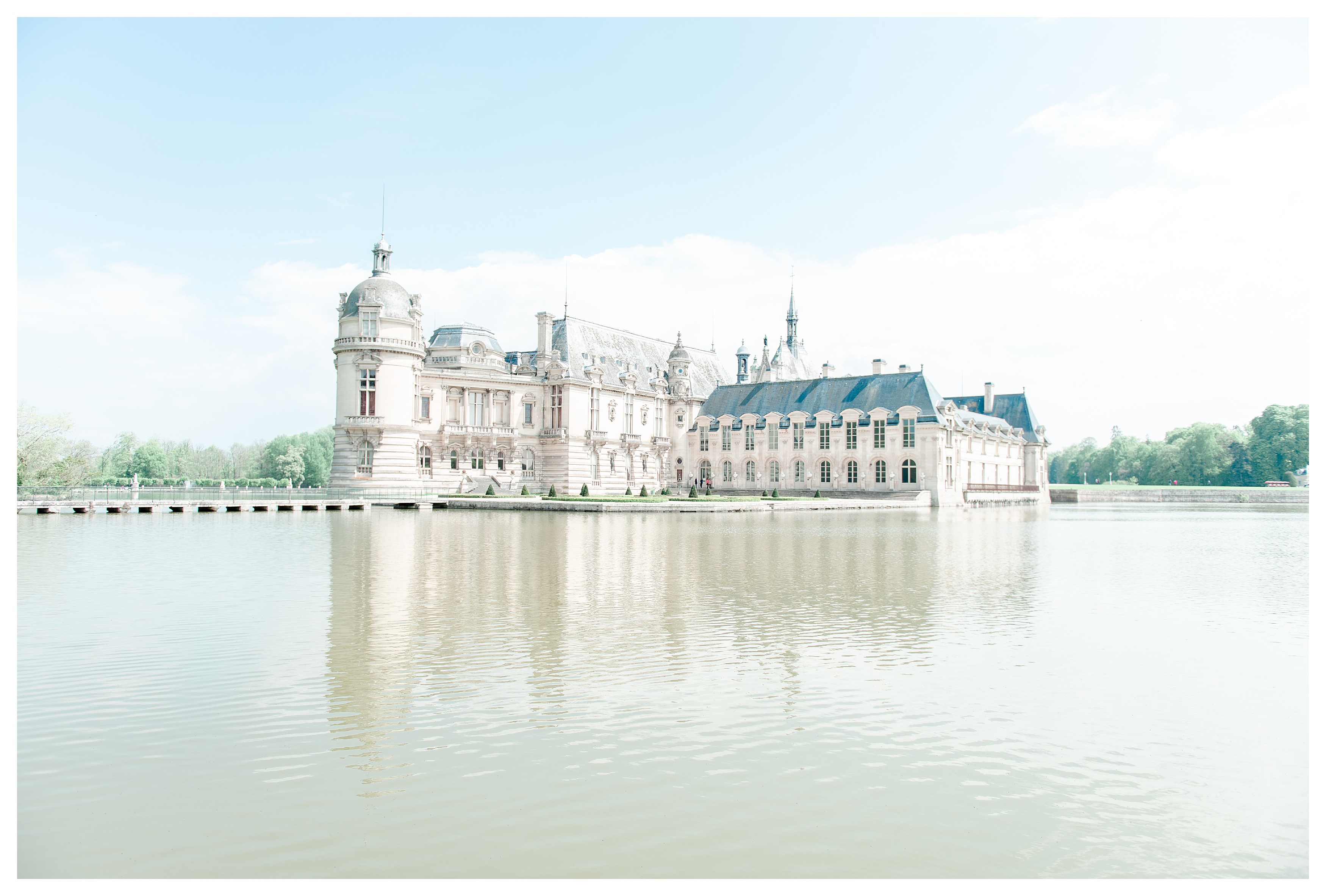 the entire château de chantilly as seen from across the lagoon