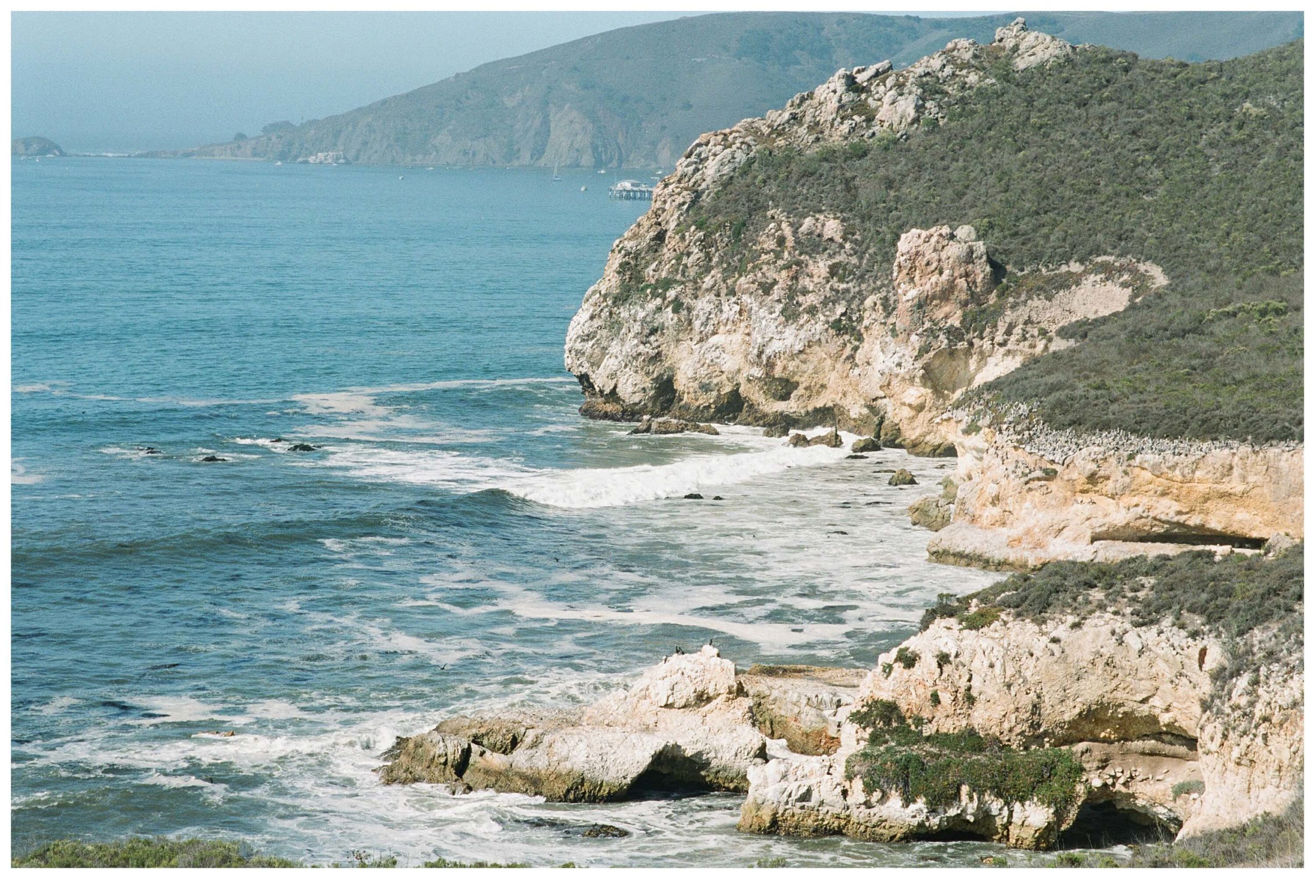 Things to do in San Luis Obispo. Sapphire-blue ocean waves crash on the rocks at Pirate's Cove in San Luis Obispo.