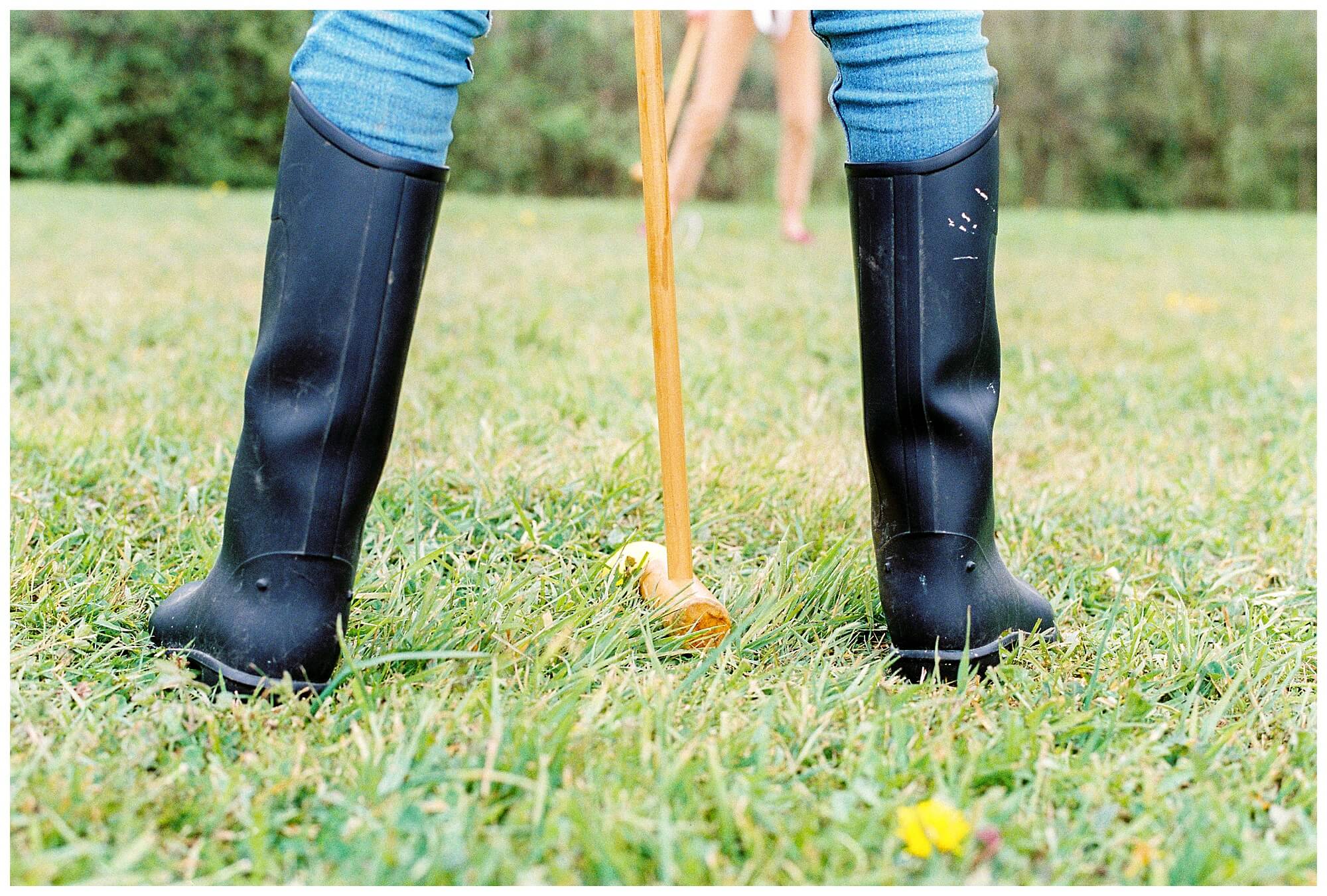 A child prepares to swing his croquet mallet during a match.