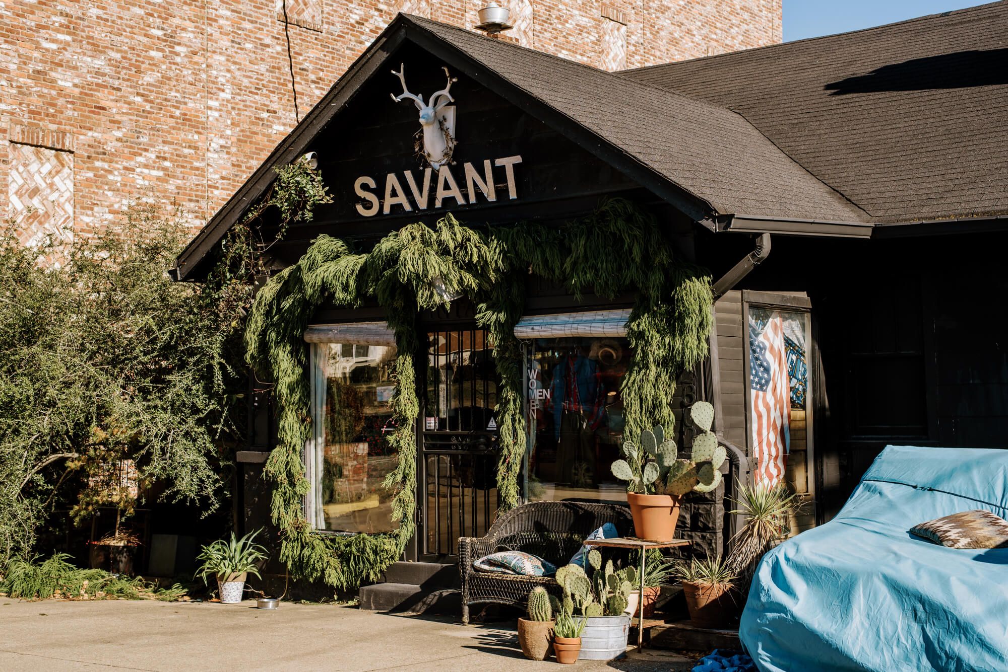 Savant Vintage in Nashville's 12 South neighborhood. It is a vintage store with many plants on sitting against the black exterior.